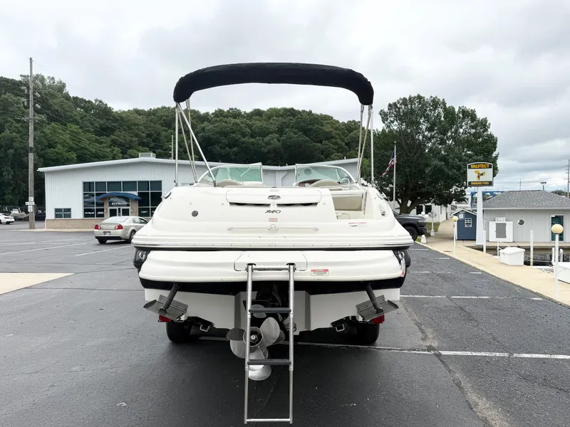 Slide: The Image of 2006 Sea Ray 240 Sundeck boat, rear view, parked on asphalt near marina. - 5