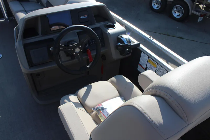 Slide: The Image of 2025 Sun Tracker Party Barge 22 RF DLX helm with steering wheel and beige seating. - 15