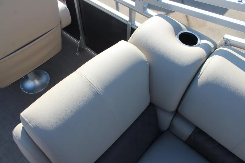 Slide: The Image of 2025 Sun Tracker Party Barge 22 RF DLX, beige seating with cup holder, close-up view. - 24