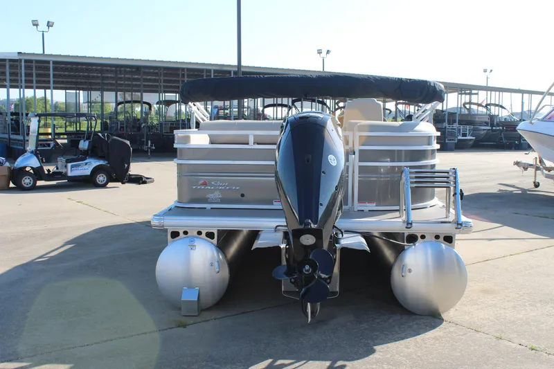 Slide: The Image of 2025 Sun Tracker Party Barge 22 RF DLX pontoon boat with outboard motor, docked outdoors. - 6