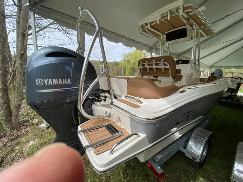 Slide: The Image of 2026 Pioneer 202 Islander boat with Yamaha engine, displayed under a tent. - 13