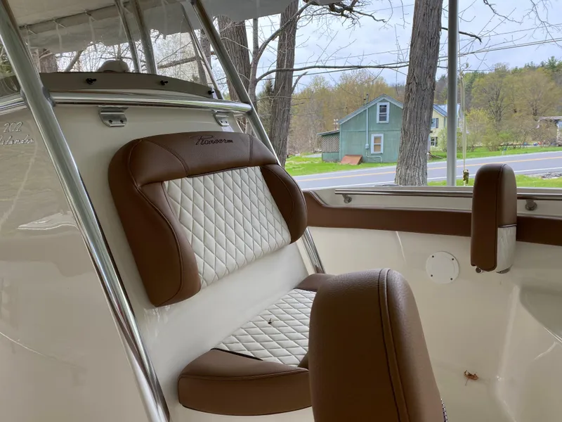 Slide: The Image of 2026 Pioneer 202 Islander boat interior with brown and white cushioned seating. - 21