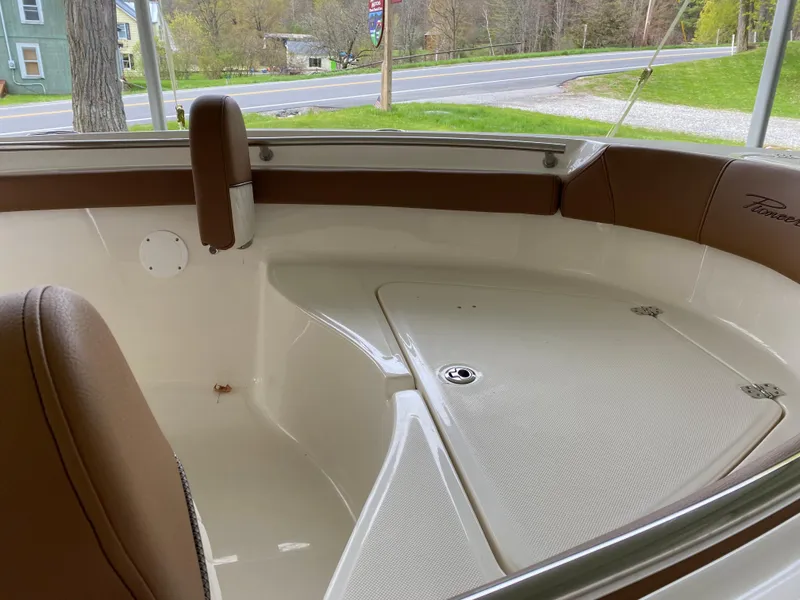 Slide: The Image of Interior of 2026 Pioneer 202 Islander boat with brown seating and white deck. - 22