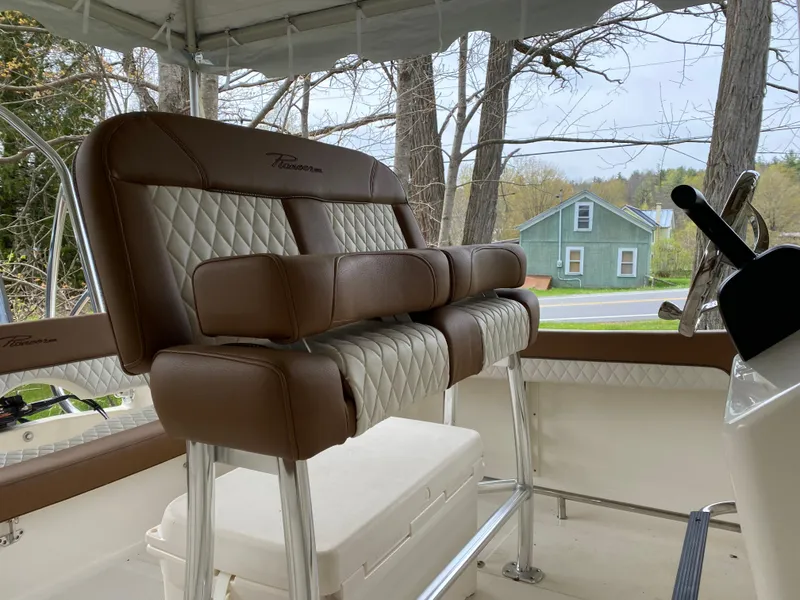 Slide: The Image of 2026 Pioneer 202 Islander boat interior with brown and white cushioned seating. - 23