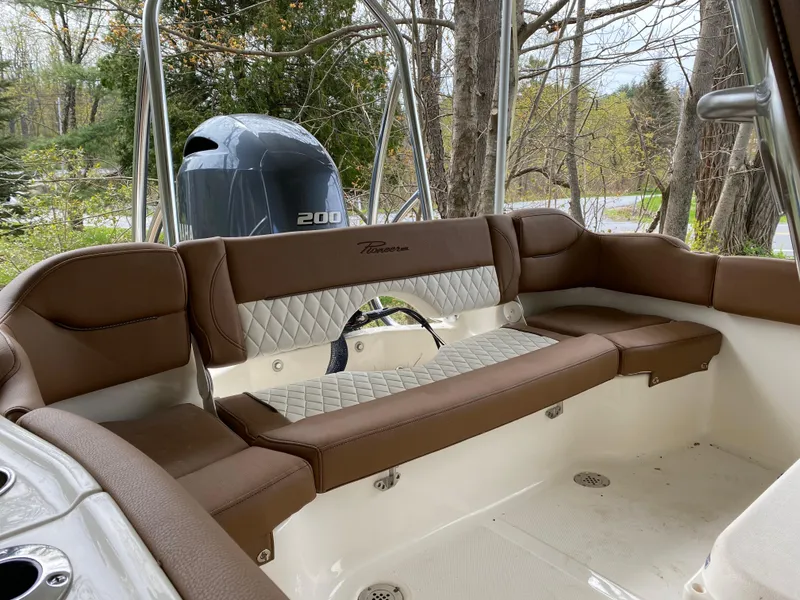 Slide: The Image of 2026 Pioneer 202 Islander boat interior with brown seating and Yamaha 200 engine. - 24