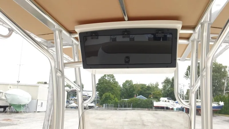 Slide: The Image of 2026 Pioneer 202 Islander boat console with overhead storage, docked in a marina. - 9