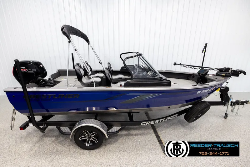 The Image of 2022 Crestliner 1850 FISHHAWK boat with trailer, blue exterior, displayed indoors. - 1