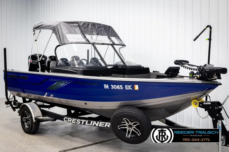 Slide: The Image of 2022 Crestliner 1850 FISHHAWK boat in blue on trailer, displayed indoors. - 3