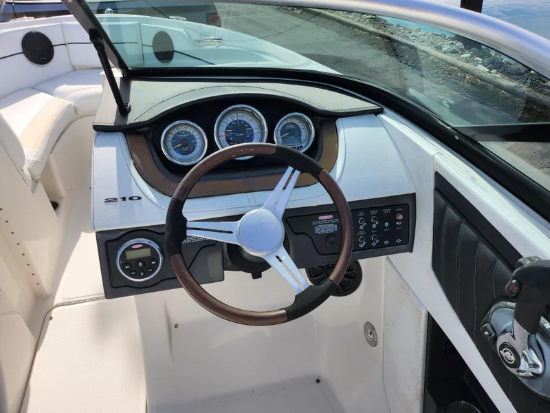 Slide: The Image of Interior view of 2014 Sea Ray 210 SLX boat dashboard and steering wheel. - 13