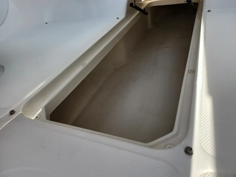 Slide: The Image of 2014 Sea Ray 210 SLX boat storage compartment, open and empty, showing interior space. - 14