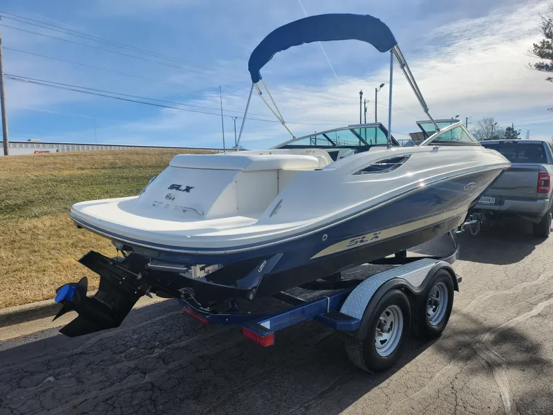 Slide: The Image of 2014 Sea Ray 210 SLX boat on trailer with blue canopy, parked outdoors. - 3