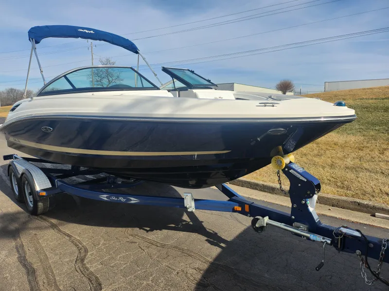 Slide: The Image of 2014 Sea Ray 210 SLX boat on trailer with blue canopy, parked on a road. - 5