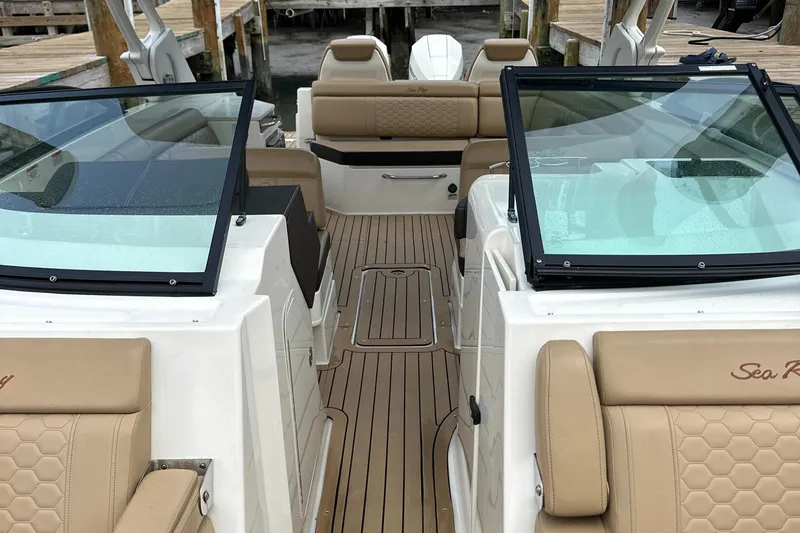 Slide: The Image of 2021 Sea Ray SDX 290 Outboard boat interior with tan seating and glass windshields. - 11
