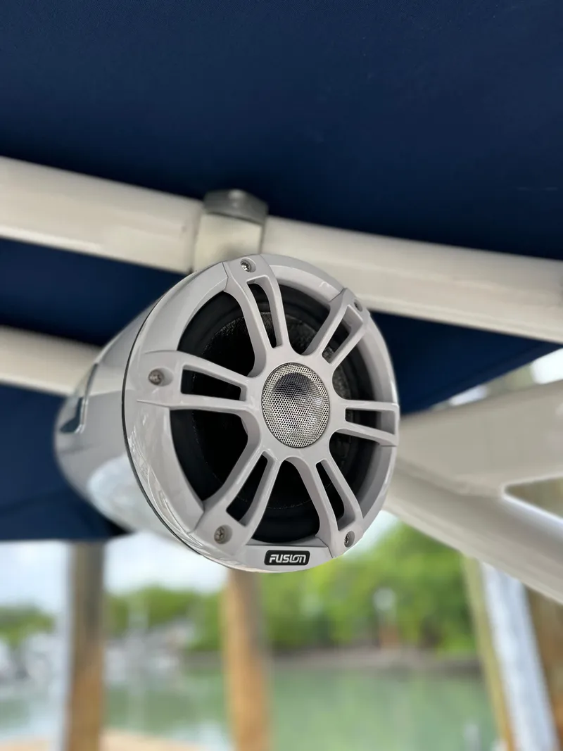 Slide: The Image of Fusion marine speaker on 2021 Sea Ray SDX 290 Outboard boat, mounted under blue canopy. - 16