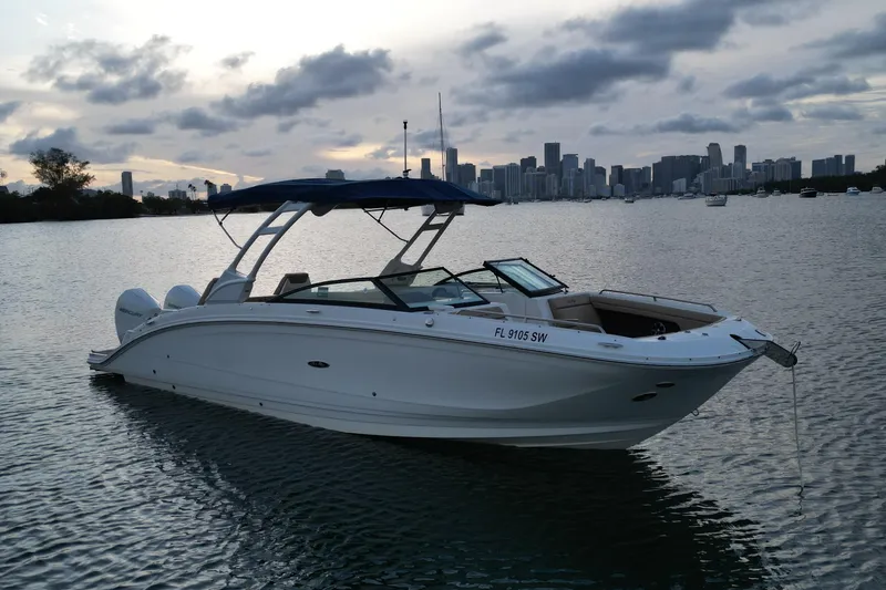 Slide: The Image of 2021 Sea Ray SDX 290 Outboard boat on water with city skyline background. - 2