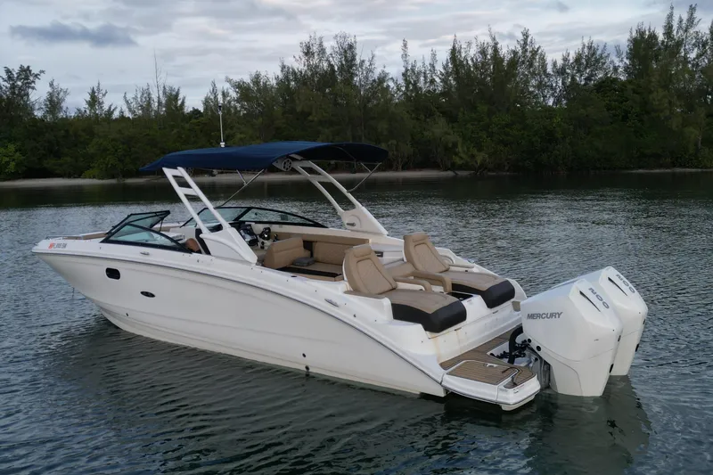 Slide: The Image of 2021 Sea Ray SDX 290 Outboard boat on calm water with lush greenery background. - 4