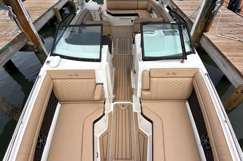 Slide: The Image of 2021 Sea Ray SDX 290 Outboard boat interior with tan seating and wood accents. - 8