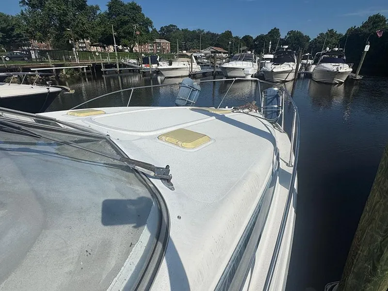 Slide: The Image of 2001 Bayliner 2855 LX Sunbridge docked in a marina, surrounded by other boats. - 3