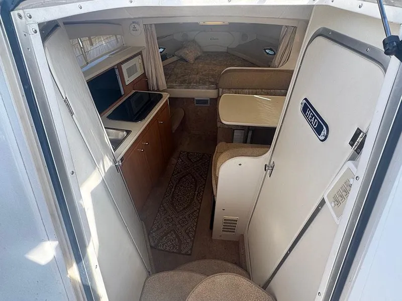 Slide: The Image of Interior of 2001 Bayliner 2855 LX Sunbridge, featuring kitchenette, seating, and sleeping area. - 6