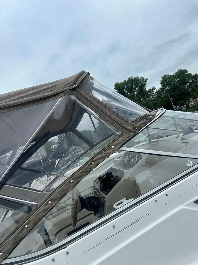 Slide: The Image of 2001 Bayliner 2855 LX Sunbridge boat with canopy and clear windows, docked outdoors. - 5