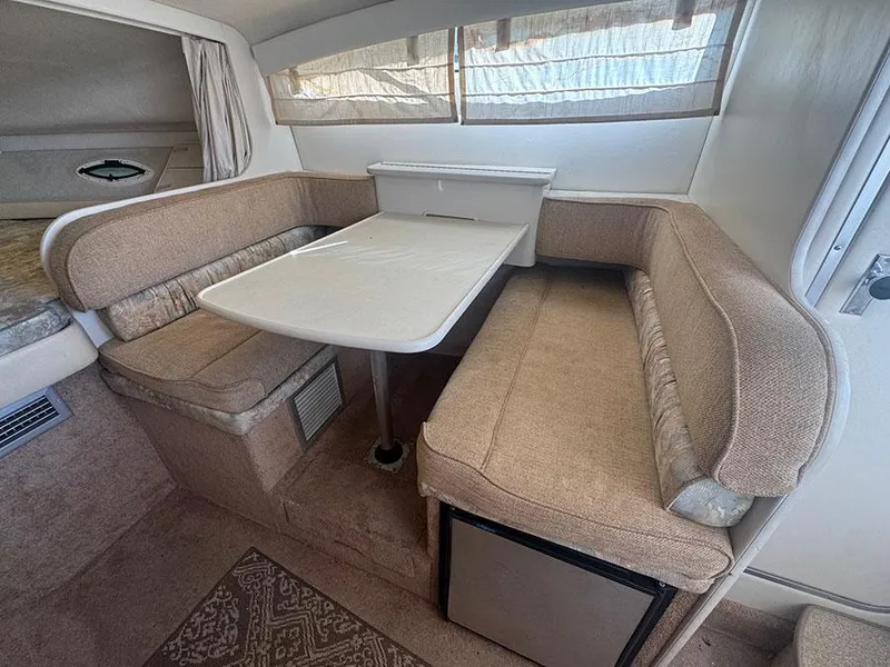 Slide: The Image of 2001 Bayliner 2855 LX Sunbridge interior with beige seating and dining table. - 8