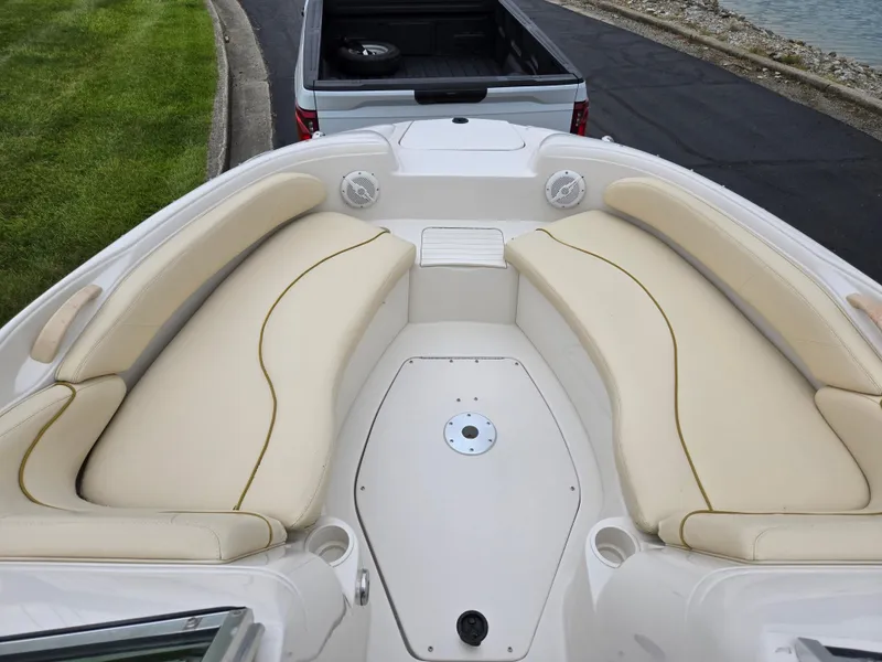 Slide: The Image of 2001 Sea Ray 210 Sundeck boat with beige seating, parked near a truck. - 17