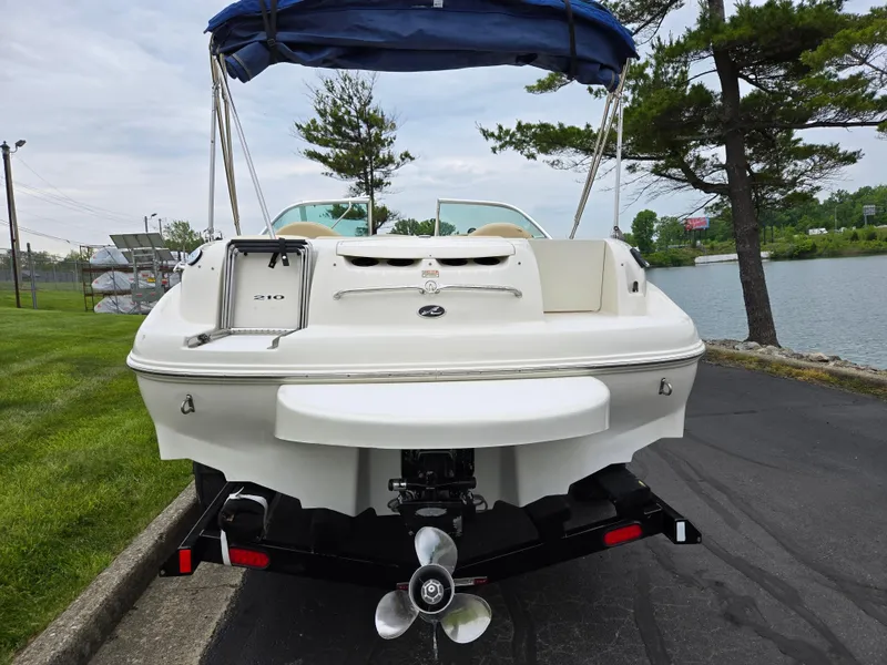 Slide: The Image of 2001 Sea Ray 210 Sundeck boat on trailer by a lakeside, rear view. - 2