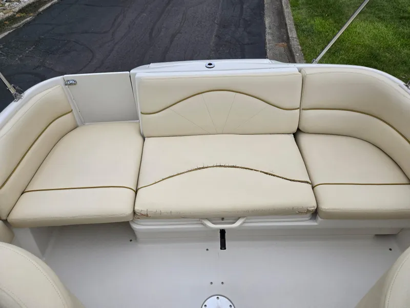 Slide: The Image of 2001 Sea Ray 210 Sundeck boat with beige cushioned seating. - 22