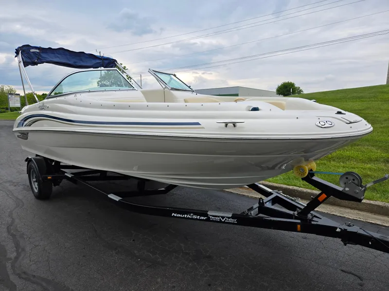 Slide: The Image of 2001 Sea Ray 210 Sundeck boat on trailer, parked outdoors, with blue canopy. - 5