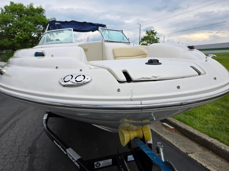 Slide: The Image of 2001 Sea Ray 210 Sundeck boat on trailer, front view, cloudy sky background. - 6