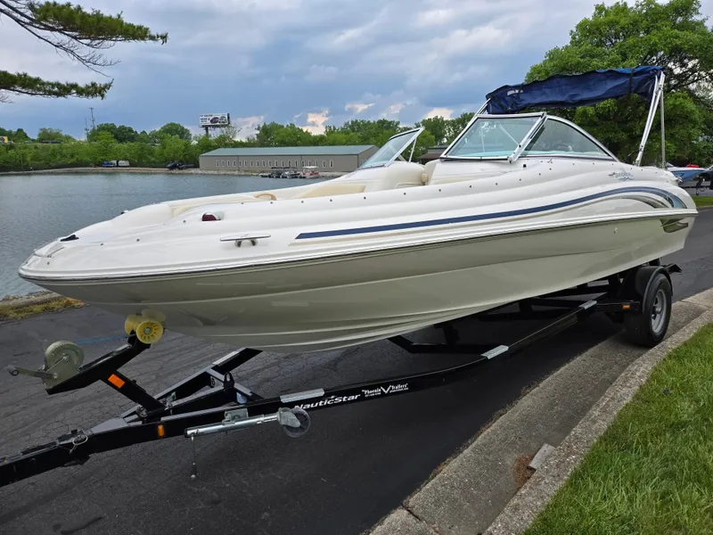 Slide: The Image of 2001 Sea Ray 210 Sundeck boat on trailer by a lakeside road. - 8