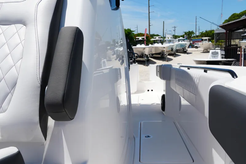 Slide: The Image of 2025 Fountain 32NX boat interior with white seating and armrests, parked outdoors. - 13