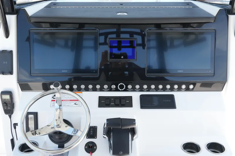 Slide: The Image of Control panel of 2025 Fountain 32NX boat with dual Garmin displays and steering wheel. - 17