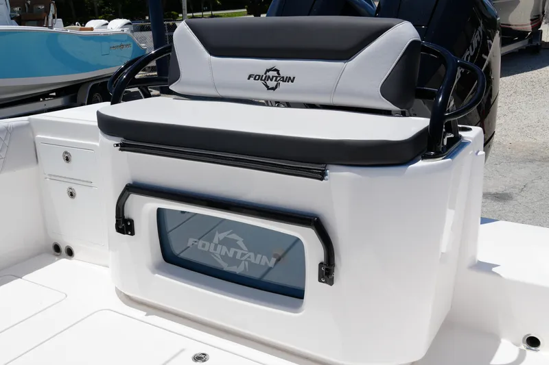 Slide: The Image of 2025 Fountain 32NX boat seating area with storage compartment, featuring sleek design and logo. - 26