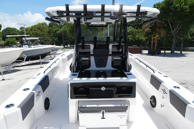 Slide: The Image of 2025 Fountain 32NX boat interior with seating and storage, docked outdoors. - 28