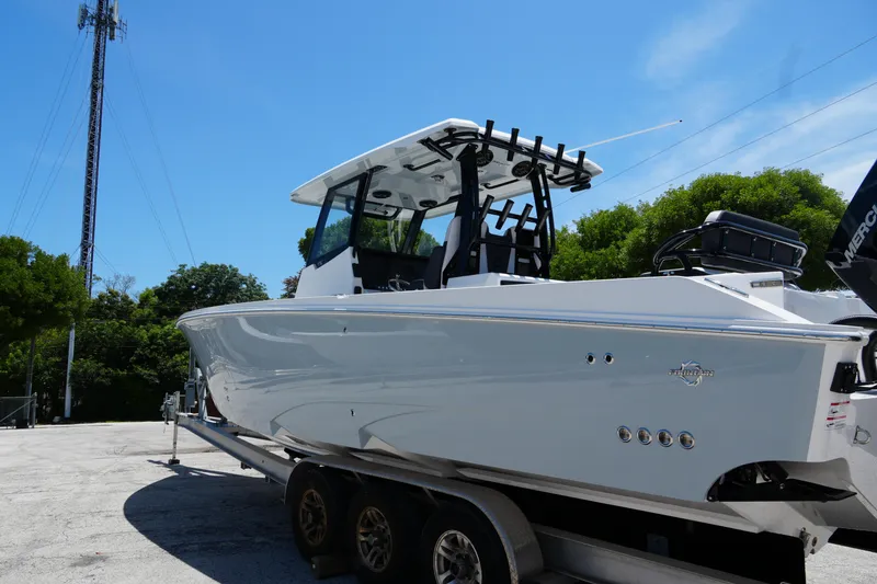Slide: The Image of 2025 Fountain 32NX boat on trailer, sleek design, clear sky background. - 6