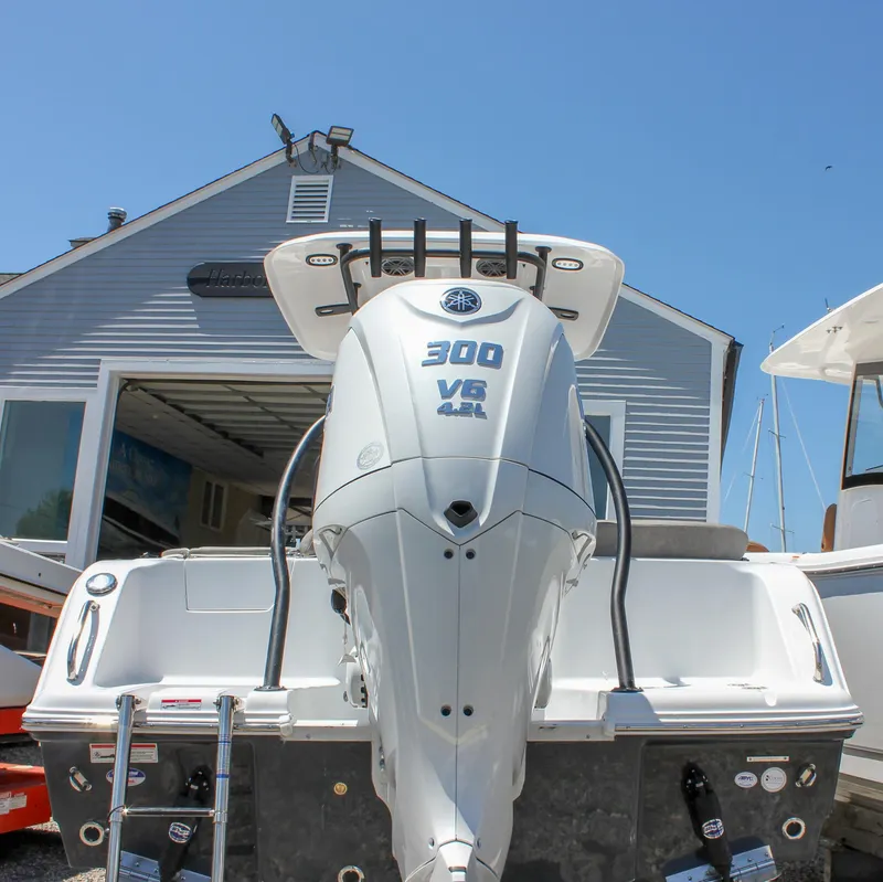 Slide: The Image of 2026 Sea Hunt Ultra 245 SE with Yamaha 300 V6 engine at a marina. - 12