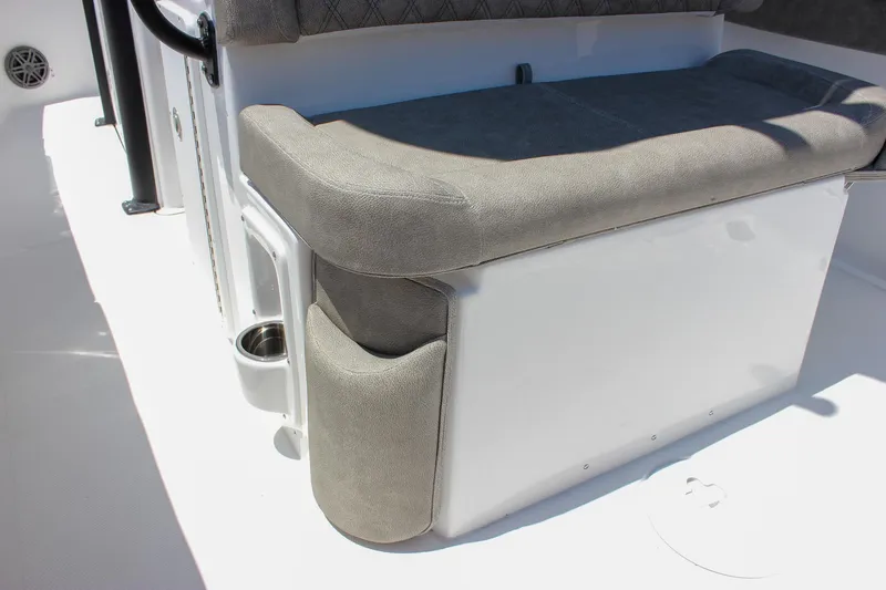 Slide: The Image of 2026 Sea Hunt Ultra 245 SE boat seating with gray upholstery and integrated cup holder. - 21