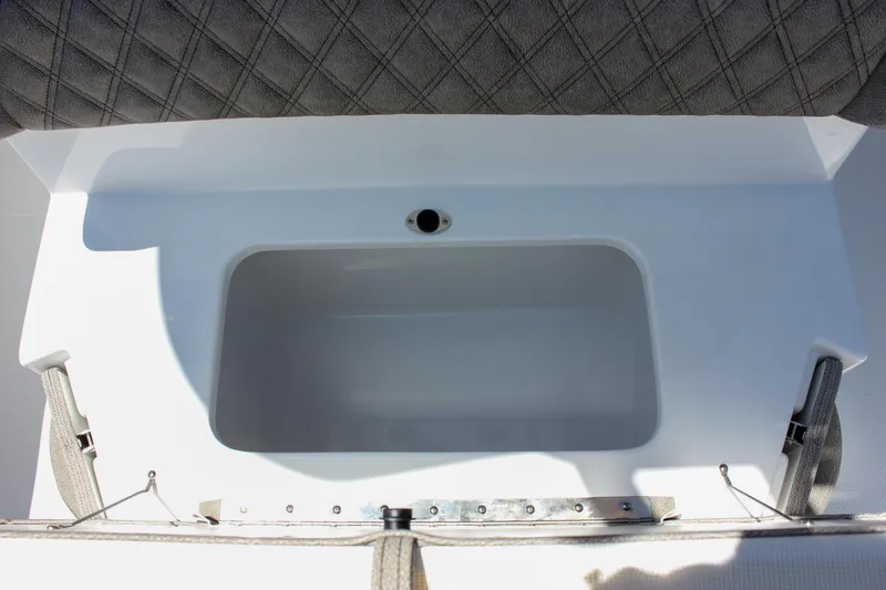 Slide: The Image of 2026 Sea Hunt Ultra 245 SE boat storage compartment with cushioned seating. - 22