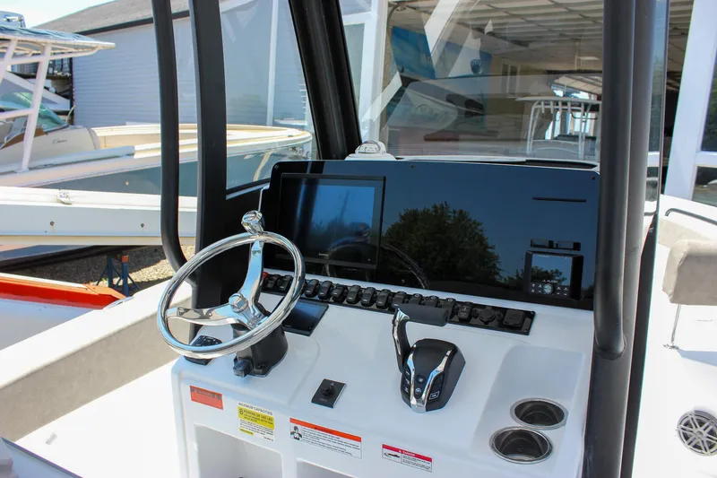 Slide: The Image of 2026 Sea Hunt Ultra 245 SE boat dashboard with steering wheel and controls. - 28