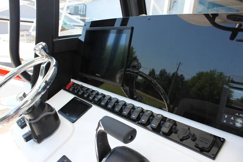 Slide: The Image of Steering console of 2026 Sea Hunt Ultra 245 SE boat with modern controls and display. - 30