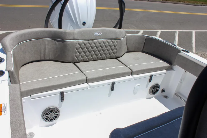 Slide: The Image of 2026 Sea Hunt Ultra 245 SE boat interior with gray cushioned seating and speaker system. - 47