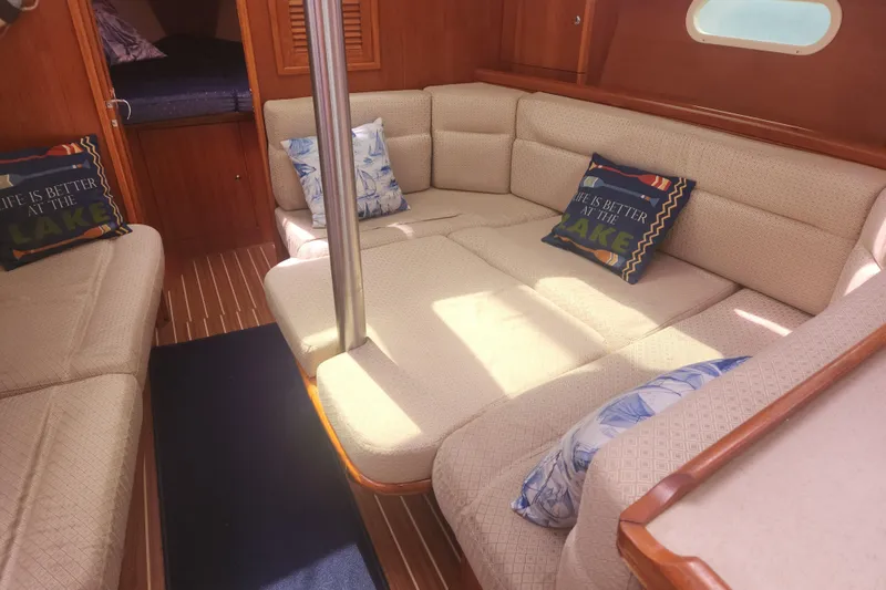 Slide: The Image of Interior of a 2004 Hunter 36 sailboat with cozy seating and decorative pillows. - 11