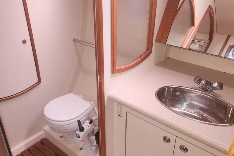 Slide: The Image of 2004 Hunter 36 yacht bathroom with toilet, sink, and wooden accents. - 12