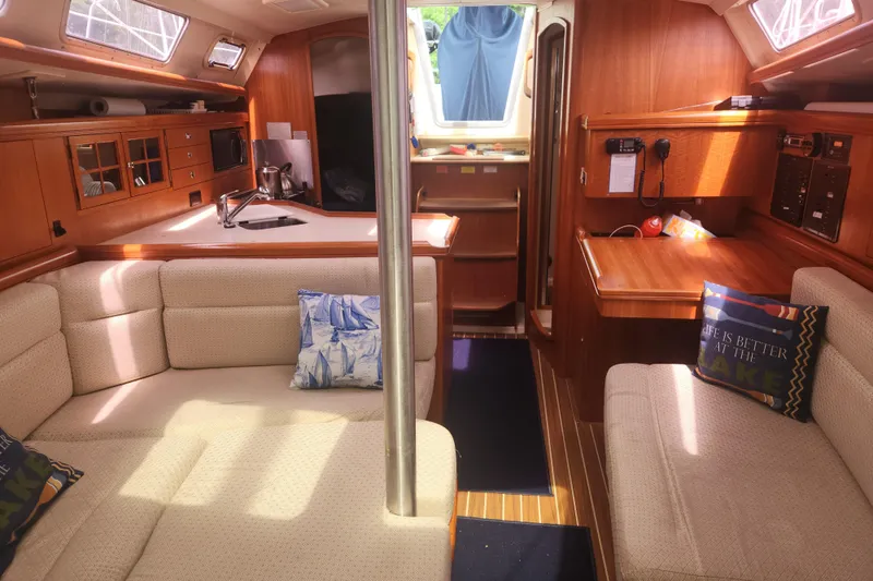 Slide: The Image of Interior of 2004 Hunter 36 sailboat with cozy seating and wooden cabinetry. - 16