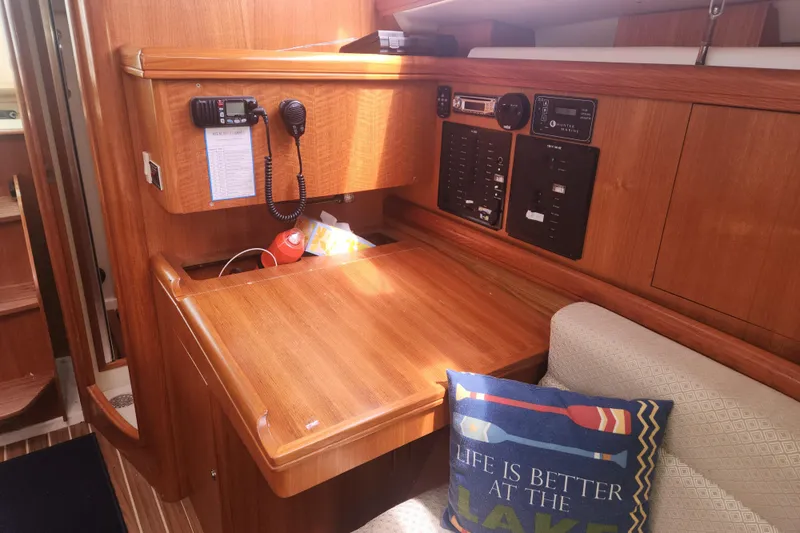 Slide: The Image of Cozy interior of 2004 Hunter 36 sailboat with navigation station and decorative pillow. - 18