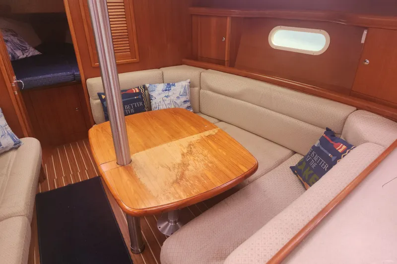 Slide: The Image of 2004 Hunter 36 sailboat interior with cozy seating and wooden table. - 20