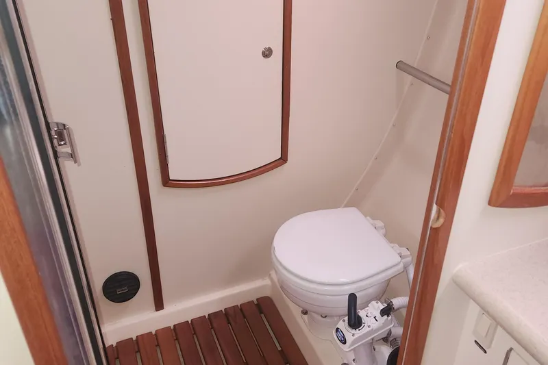 Slide: The Image of 2004 Hunter 36 yacht bathroom with wooden accents and compact marine toilet. - 22