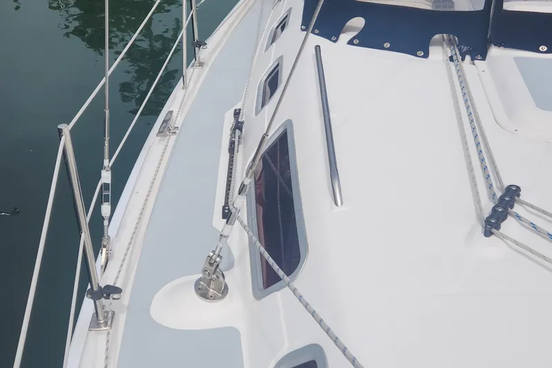 Slide: The Image of 2004 Hunter 36 sailboat deck with rigging and windows, docked on calm water. - 36