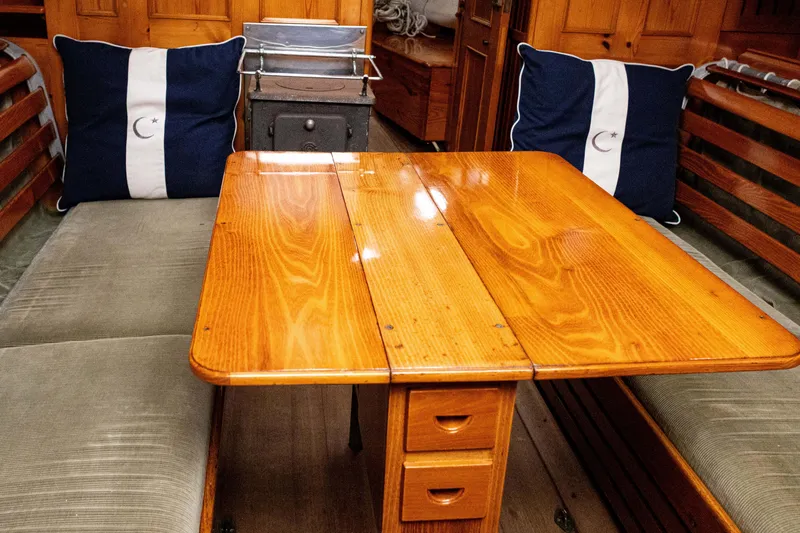 Slide: The Image of Vintage Concordia 39 sailboat interior with wooden table and nautical-themed cushions, 1964 model. - 10